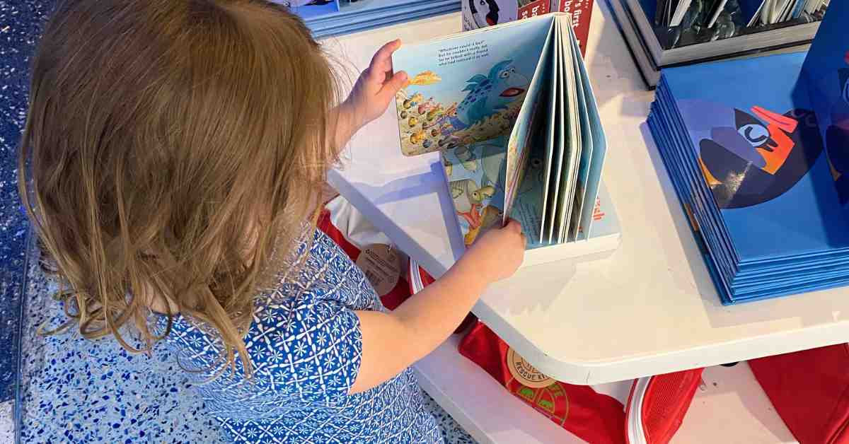 Preschooler exploring books at the the Georgia Aquarium