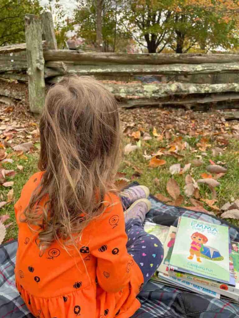 Preschooler with books about camping