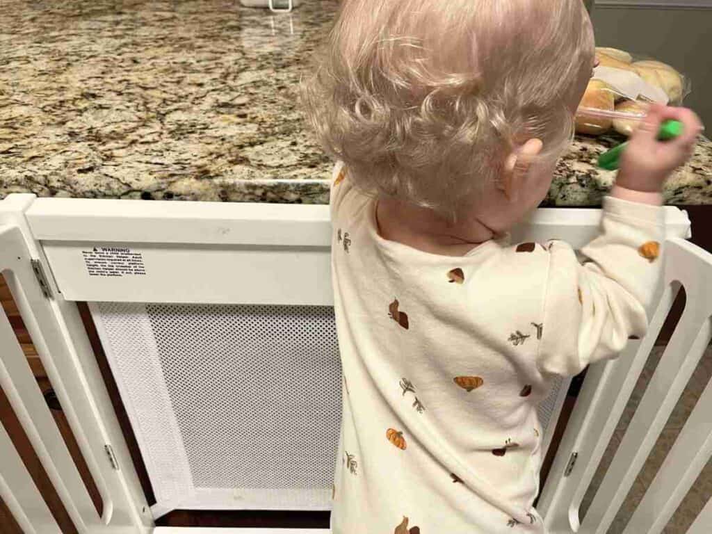 Baby standing in a Montessori kitchen helper