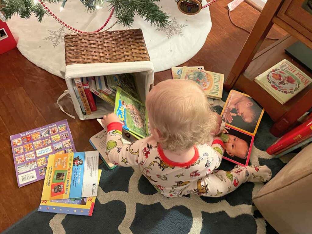 Baby looking through a basket of books