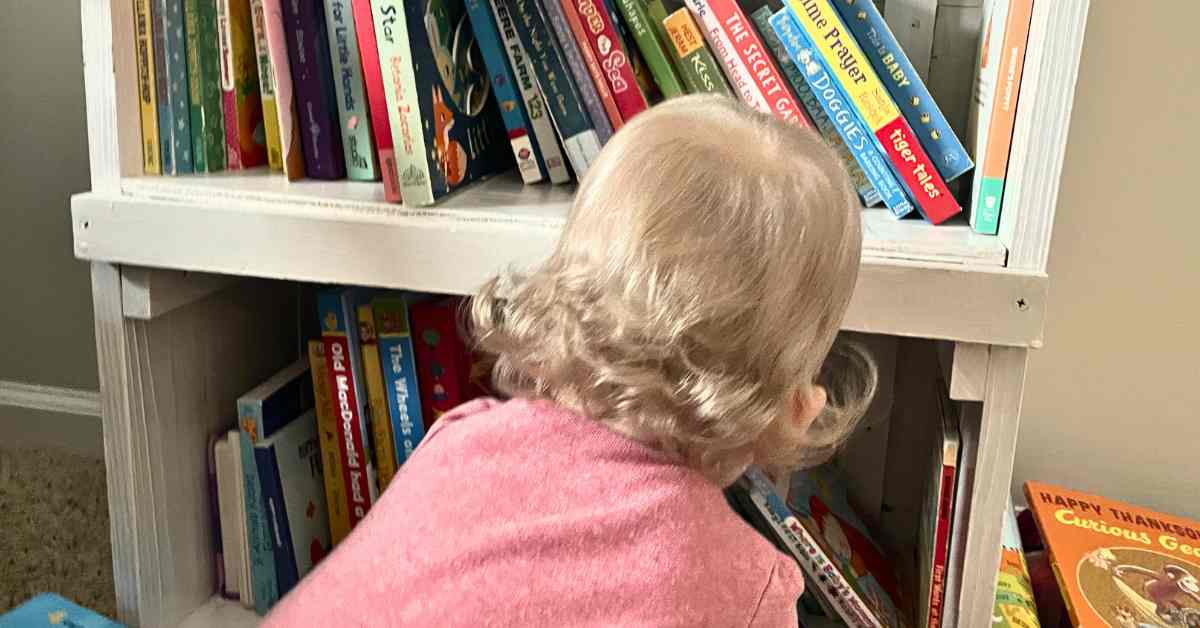 Baby pulling books off of a shelf