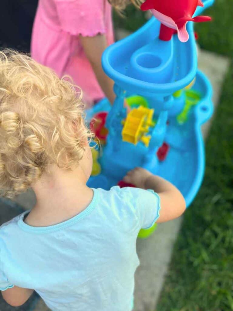 toddler playing with water table