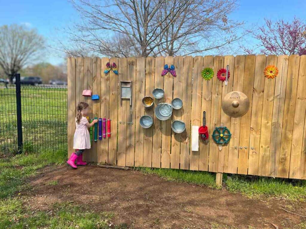 Preschooler exploring outdoor music wall