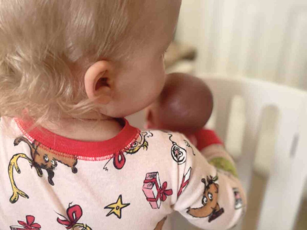 Toddler loving on a babydoll