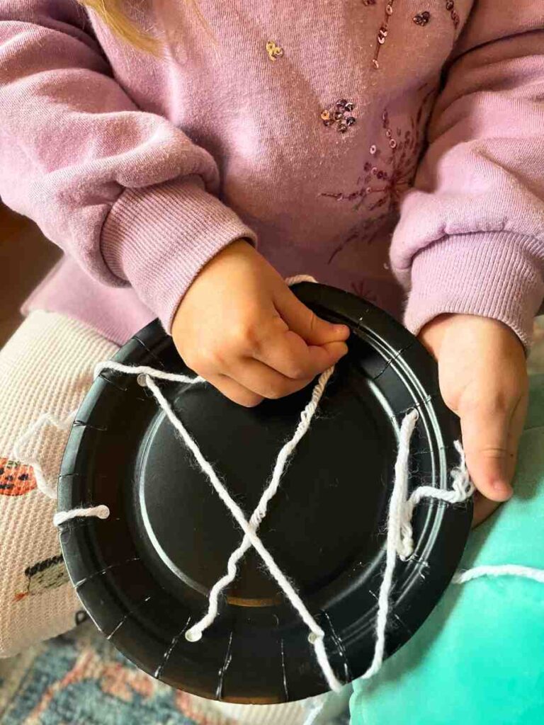 Preschool sewing a paper plate spider web fine motor skills Halloween activity