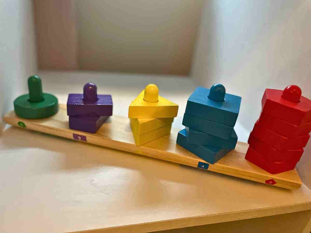 Shape sorter and stacker toy on an open shelf