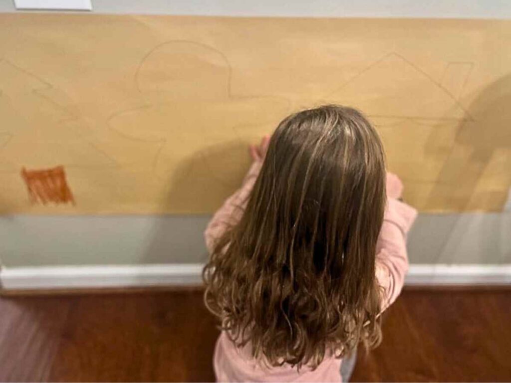 preschooler decorating a gingerbread wall at Christmas time