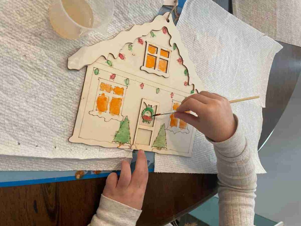 Preschooler painting a gingerbread house
