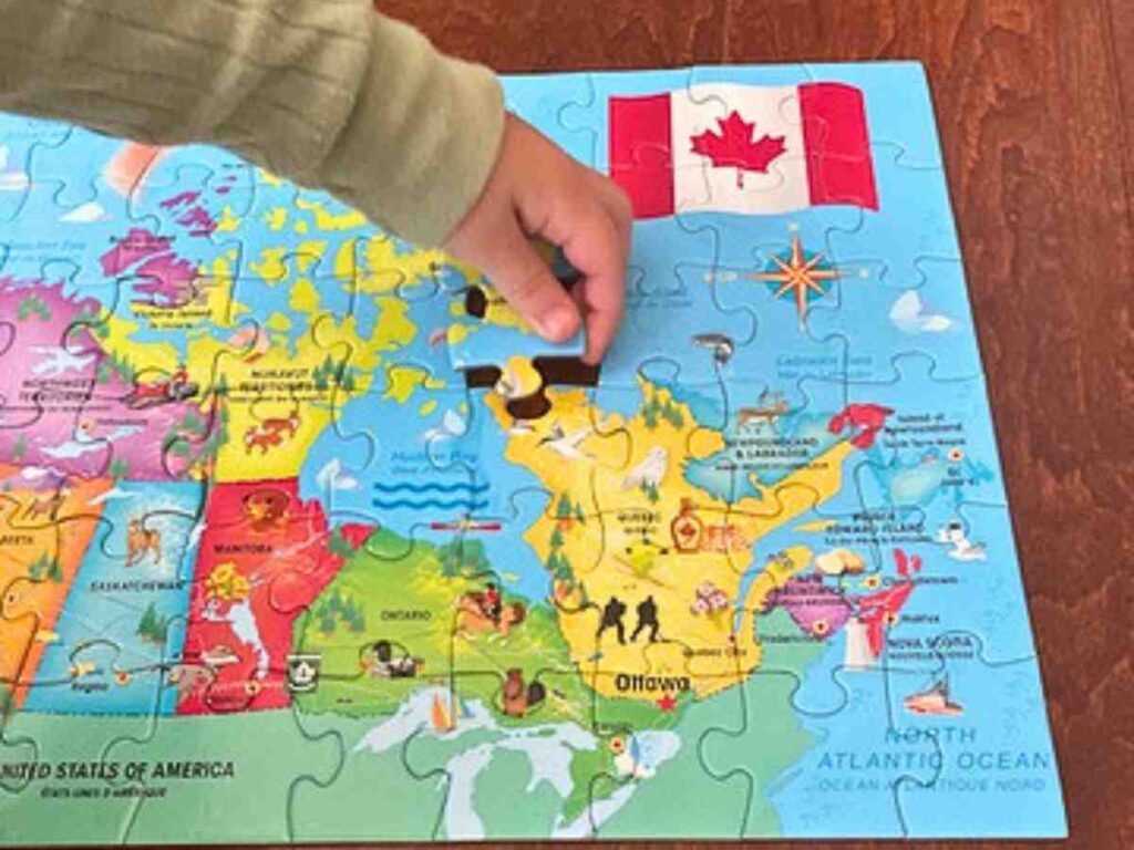 preschooler finishing a puzzle of Canada